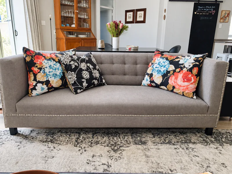 Grey sofa with richly patterned colourful floral cushions