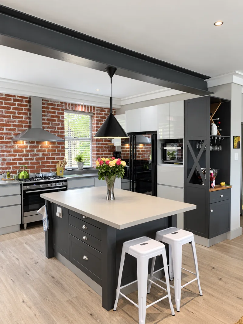 Charcoal kitchen cabinetry, exposed brick and white island countertop